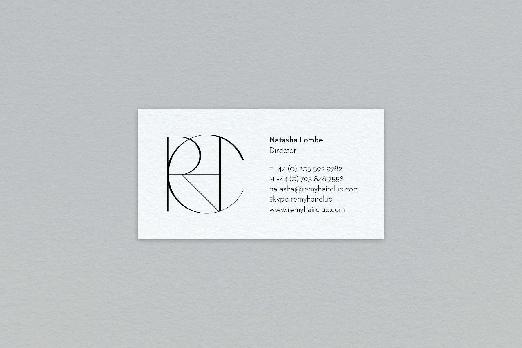 Remy Hair Club business card with emblem and contact details